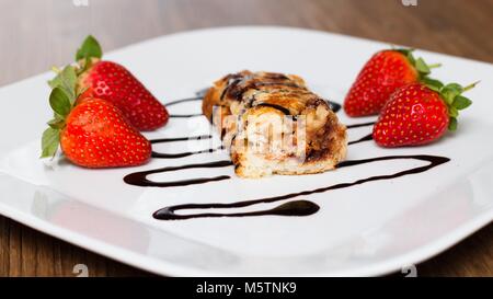 Roulé au chocolat surmontée du pain perdu aux fraises Banque D'Images