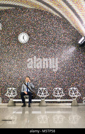 Man avec le smartphone dans une station de métro. Banque D'Images