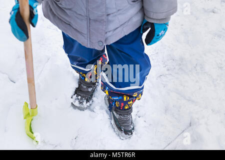 Aider l'enfant à partir de la neige du trottoir. Activités hiver famille authentique franc. Pelleter la neige concept. Banque D'Images