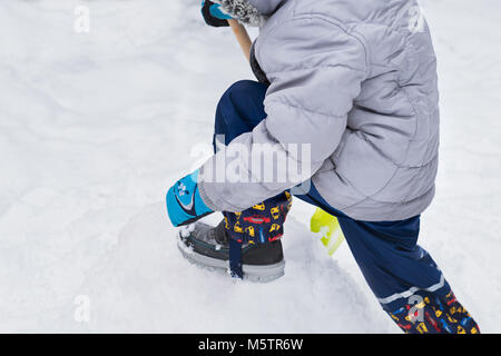 Aider l'enfant à partir de la neige du trottoir. Activités hiver famille authentique franc. Pelleter la neige concept. Banque D'Images