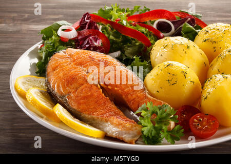 Poêlée de saumon et légumes sur table en bois Banque D'Images