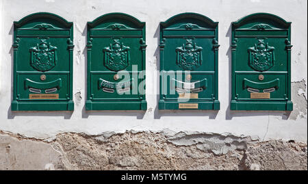 Une rangée de quatre vieux vert boîtes aux lettres sur le mur d'un immeuble à Sorrento, Italie. Banque D'Images