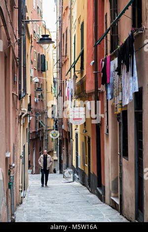 Homme marchant dans une ruelle typique dans le centre historique de Gênes, ligurie, italie Banque D'Images