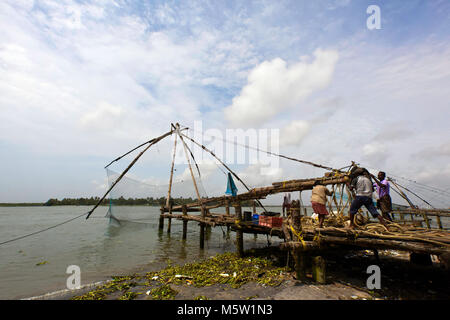 Les pêcheurs au travail sur le filets de pêche chinois. De Kochi (Cochin) au Kerala, en Inde. Banque D'Images