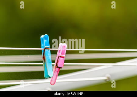 Deux vieux avec des pinces en plastique métal rouillé sur une ligne de lavage rotatif avec bokeh et copier l'espace. Banque D'Images