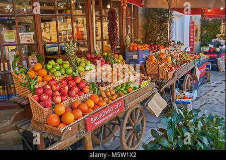 Fruits et légumes à l'ancienne barrow affichant un large éventail de fruits et légumes frais à l'extérieur du magasin deli local à Broadway, Worcestershire Banque D'Images