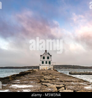 Les nuages colorés au-dessus de la lumière d'un brise-lames du port de Rockland Banque D'Images