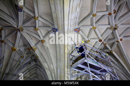 Membre de la Canterbury Archaeological Trust utilise un aspirateur sac à dos dans une opération de nettoyage pour enlever rares des décennies d'accumulation de poussière et de salissures sur le toit de la nef de la Cathédrale de Canterbury, Kent. Banque D'Images