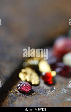 Le grenat almandin rouge profond, pépites d'or et d'un rubis rose, le tout à partir de la Finlande Banque D'Images