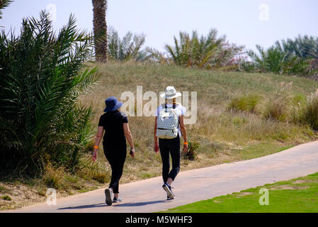 Deux jeunes femmes marchant sur une piste de jogging au golf Saadiyat Island, Abu Dhabi Banque D'Images