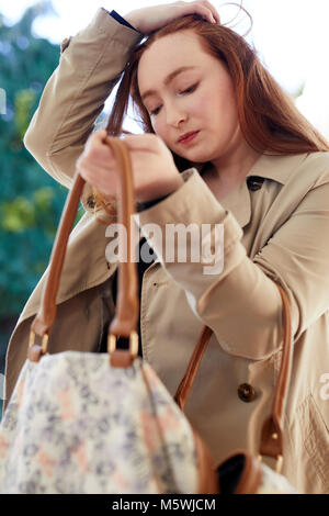 Femme à la recherche de son sac pour les objets volés Banque D'Images