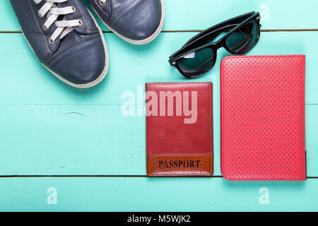 Set de voyage, Passeport, e-book, chaussures, lunettes de soleil. on a wooden surface turquoise, une vue de dessus Banque D'Images