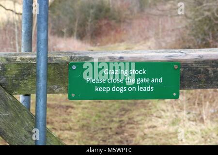 'Herbivores veuillez fermer la porte et de maintenir les chiens sur des pistes' panneau vert sur la porte en pleine campagne, au Royaume-Uni. Banque D'Images