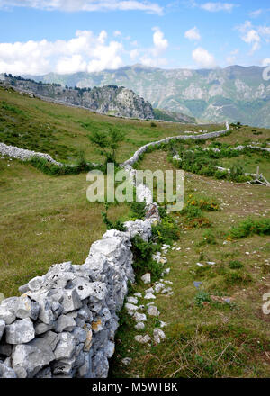 Vue sur les montagnes depuis les montagnes Cantabriennes, nord de l'Espagne. Premier plan Rocky avec vieux mur. Chaîne de montagnes avec ciel bleu et nuages. Banque D'Images