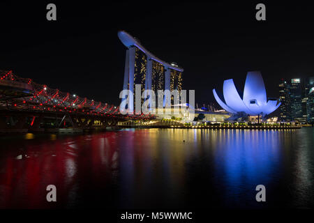 Voir à la Marina Bay à Singapour de nuit avec les monuments célèbres de l'Hélix Bridge et le Marina Bay Sands. Banque D'Images