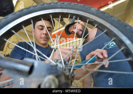 Mohammad Khilo (à gauche), une réfugiée de la Syrie, travaille sur un vélo à la roue commune à Lancaster, en Pennsylvanie, supervisé par Chris Caldwell. Banque D'Images