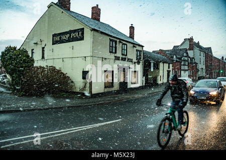 , Leominster Herefordshire, UK. Feb 26, 2018. Un homme chevauche son vélo lors d'une averse de neige dans la ville de Leominster, le 26 février 2018. Storm Emma est prête à frapper le Royaume-Uni le jeudi et vendredi, ce qui porte le poids de la neige, des tempêtes et des vents forts.Le temps le système connu sous le nom de 'bête de l'Est' a déjà commencé à travers le pays. Certaines parties du Royaume-Uni sont mis à se sentir plus froide que le cercle polaire en températures de gel sont à prévoir pour le reste de la semaine. Crédit : Jim Wood/Alamy Live News Banque D'Images