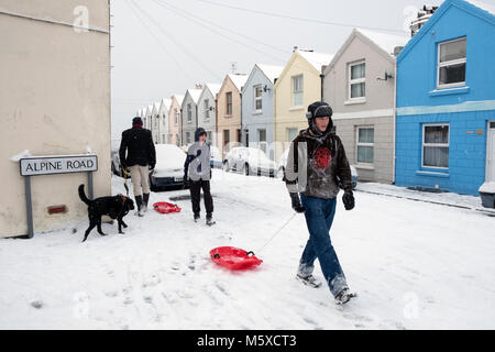 Hastings, East Sussex, UK. Feb 27, 2018. Météo France : Lads avec traîneaux en profitant de la neige avec de la neige tombant sur la bien nommée route Alpine, sur la colline de l'Ouest, à Hastings, East Sussex, UK. Banque D'Images