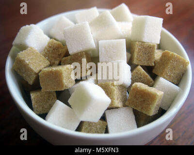 Cubes de sucre brun et blanc dans un bol en céramique Banque D'Images