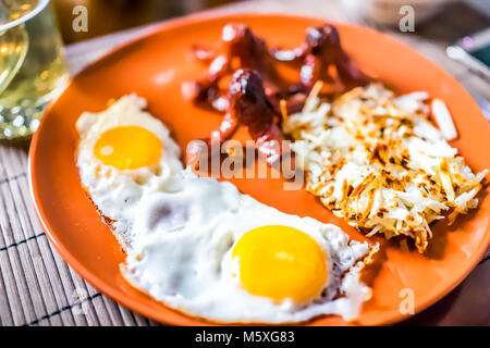 Gros plan du grand plateau petit-déjeuner brunch avec les œufs, les pommes de terre Rissolées pommes râpé, saucisse tako poulpe, verre jaune Banque D'Images