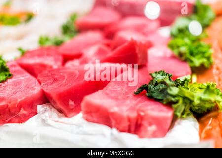 Stand de fruits de mer avec des compressions de rouge rose sauvage d'élevage steaks de thon sur la glace avec des feuilles de chou Banque D'Images