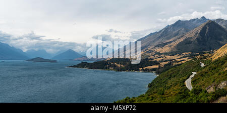 Route sinueuse en direction de montagnes entourant le lac Wakatipu, Nouvelle-Zélande Banque D'Images