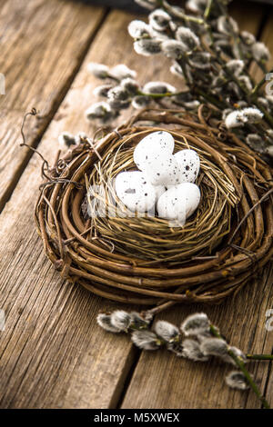 Les oeufs de Pâques sur le bois. Maison de vacances de Pâques avec des oeufs de wisker concept panier dans la nature Banque D'Images