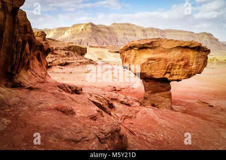 Rock formation géologique appelée mushroom entouré de roches rouges de Timna park en grès sec désert du Néguev, Eilat, Israël. Journée ensoleillée d'hiver avec Banque D'Images