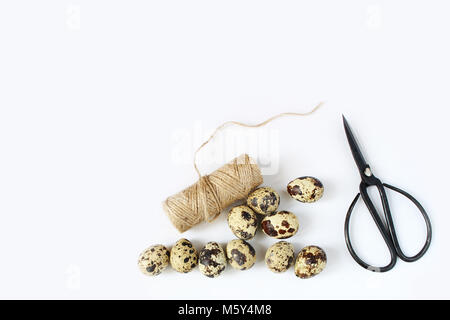 Printemps Pâques, carte de vœux, invitation avec des oeufs de cailles, ciseaux noir et blanc naturel corde sur table. Style Féminin télévision stock lay photo, vue d'en haut. Banque D'Images