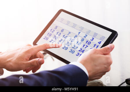 Close-up de l'homme d'affaires à l'aide de la main de calendrier sur tablette numérique Banque D'Images