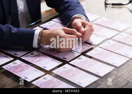 Close-up de l'homme d'affaires, l'Arrêté menottes pour soudoyer avec des billets en euros sur 24 Banque D'Images