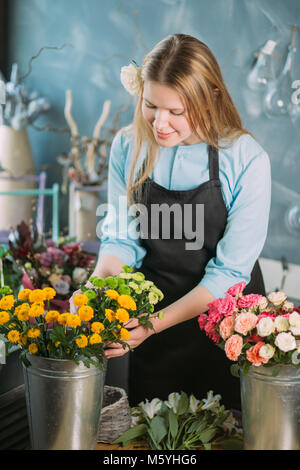 Photo de cute woman putting mimosas en vase Banque D'Images