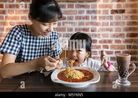 Chinois asiatique mother and daughter eating spaghetti bolognese dans le restaurant Banque D'Images