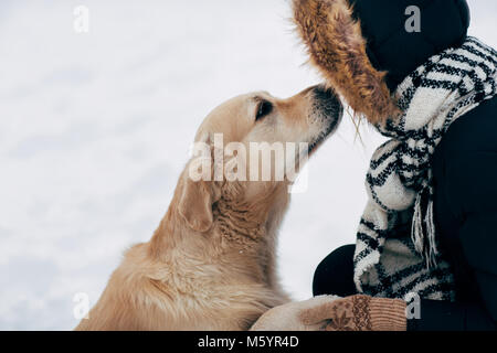 Photo de labrador patte donnant de woman in black Jacket sur l'hiver Banque D'Images