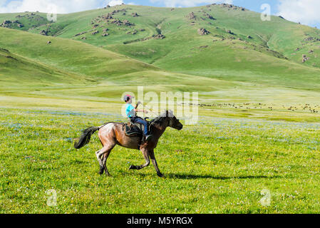 Son cheval équitation garçon kirghize, Song Kol Lac, province de Naryn, du Kirghizistan, de l'Asie centrale Banque D'Images