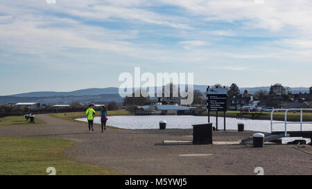 Deux femelles d'exécution par l'Clachnaharry Sea Loch où le Canal Calédonien répond à l'estuaire de Beauly, Inverness, Scotland Banque D'Images