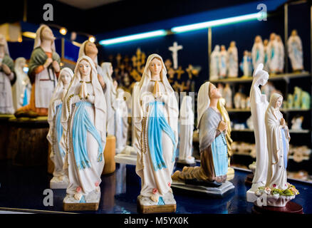 Lourdes (sud-ouest de la France). Boutique de souvenirs, des statuettes de la Vierge Marie et Sainte Bernadette Soubirous en vente Banque D'Images