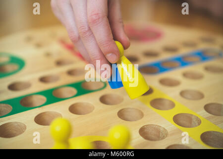 Enfant jouant Ludo jeu de plateau. Vue rapprochée. Banque D'Images