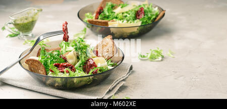 La jeune niçoise Salade de laitue, tomates séchées au soleil, fromage, pain, chips et au pesto Banque D'Images