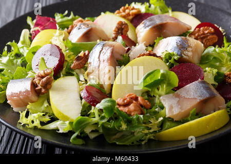 Salade de poisson : maquereau fumé avec apple, noyer, la betterave et la laitue sur une assiette sur une table horizontale. Banque D'Images