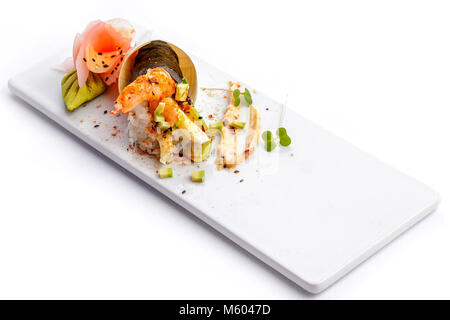 Rouleaux de Sushi sur une plaque blanche avec fond blanc. Banque D'Images