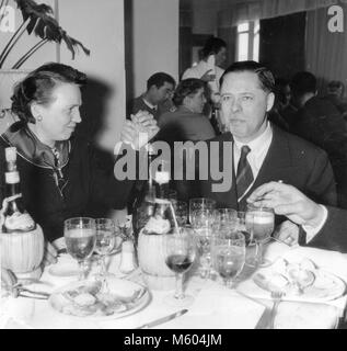 Famille mariage heureux de manger les mains lors d'un défi en 1970 mariage en Italie. Carré noir et blanc tourné. Banque D'Images