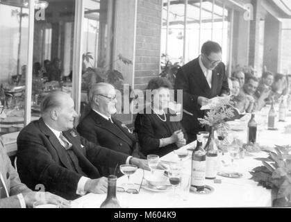 Famille mariage heureux de manger pendant un 1970 mariage en Italie. Tourné en noir et blanc. Banque D'Images