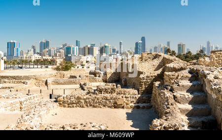 Ruines du Fort de Bahreïn avec des toits de Manama. Site du patrimoine mondial de l'UNESCO Banque D'Images
