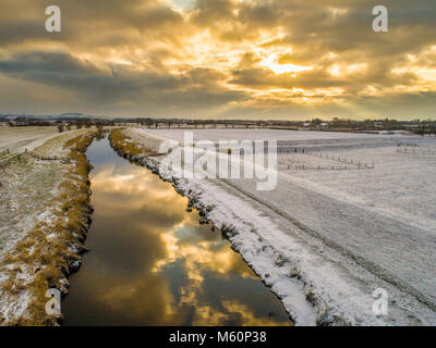 Great Eccleston, UK. 27 février 2018. Drone saisit le lever du soleil sur la neige couverts champs autour de la rivière Wyre. Les nuages se reflètent dans la rivière et la rivière glacée peut être vu de chaque côté., avec les Pennines à l'arrière-plan. Millner Russell / Alamy Live News. Banque D'Images