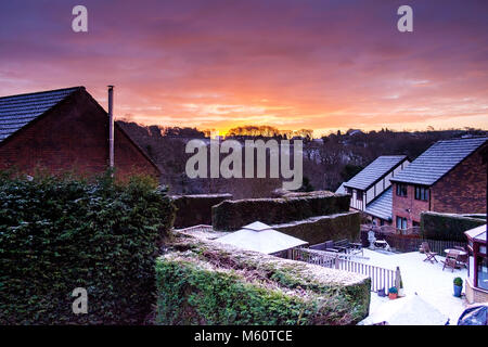 Swansea, Pays de Galles, Royaume-Uni. 27 févr. 2018. Météo France : Suburbia retour jardins couverts de neige de la bête à l'Est, avec un lever du soleil par-dessus les collines et les arbres Crédit : Sian Pearce Gordon/Alamy Live News Banque D'Images