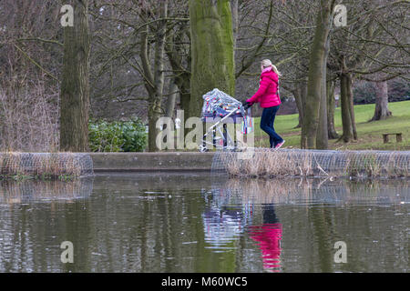 Northampton, Angleterre, Abington Park. Météo au Royaume-Uni. 27 février 2018. La Bête de l'Est n'est pas arrivé à Northampton, encore un couple de lumière averses de neige au cours de la matinée mais rien jeter, les températures sont autour de 0 degrés vers la fin du matin avec quelques périodes ensoleillées pour une dame avec son bébé marche autour du lac. Credit : Keith J Smith./Alamy Live News Banque D'Images