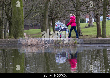 Northampton, Angleterre, Abington Park. Météo au Royaume-Uni. 27 février 2018. La Bête de l'Est n'est pas arrivé à Northampton, encore un couple de lumière averses de neige au cours de la matinée mais rien jeter, les températures sont autour de 0 degrés vers la fin du matin avec quelques périodes ensoleillées pour une dame avec son bébé marche autour du lac. Credit : Keith J Smith./Alamy Live News Banque D'Images