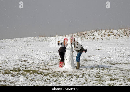 Hastings, hiver, East Sussex, Royaume-Uni, 27 février 2018. Un couple prend un selfie de leur bonhomme de neige dans le paysage enneigé, au Ladies' Parlor Banque D'Images