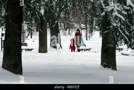 (180227) -- BELGRADE, Février 27, 2018 (Xinhua) -- une femme et un enfant qui marche à travers le parc enneigé à Belgrade, Serbie le 27 février 2018. (Xinhua/Predrag Milosavljevic)(HR) Banque D'Images